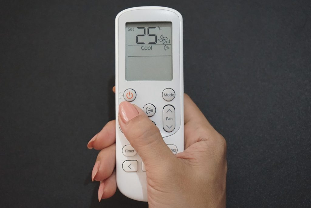 A woman’s use remote control the air conditioning